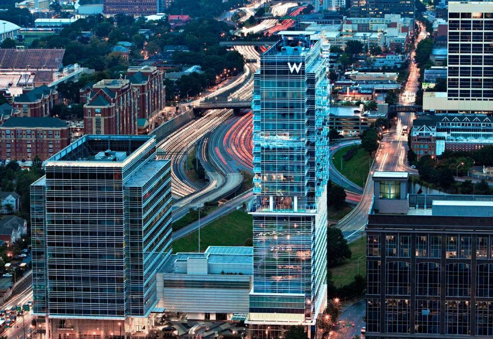 a city skyline at dusk , with a tall building in the foreground and a busy highway in the background at W Atlanta – Downtown