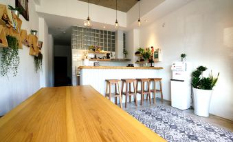 a modern kitchen with a wooden table and chairs , white pendant lights , and a counter with stools at Red House
