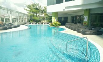 There is a large swimming pool with blue water and white tiled walls in the center at Wyndham Grand Bangsar Kuala Lumpur(Formerly Pullman Kuala Lumpur Bangsar)