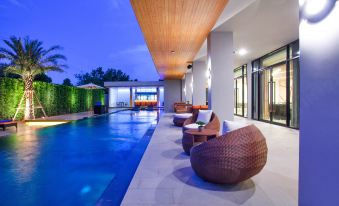 A large swimming pool with ample seating is located next to the outdoor sitting area at The Zense Boutique Hotel