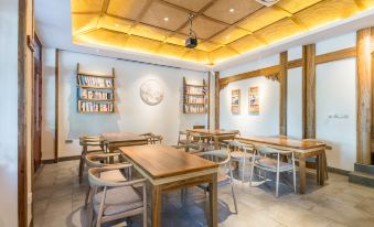 a room with wooden tables and chairs , bookshelves on the wall , and a framed picture at Riverview Hotel