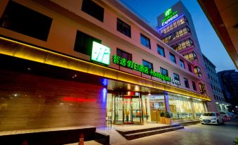 The hotel's front entrance is shown in a time-lapse video at night, featuring an illuminated sign above it at Holiday Inn Express Xi'an Bell Tower