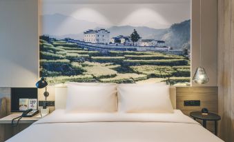 The bedroom features large windows and a wall-mounted image depicting proximity at Atour Hotel (Yiwu International Trade City)