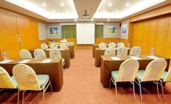 a conference room set up for a meeting , with chairs arranged in rows and a projector on the wall at Bay Hotel Srinakarin