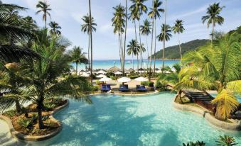 a beautiful swimming pool with umbrellas and palm trees , surrounded by palm trees and the ocean at The Taaras Beach & Spa Resort