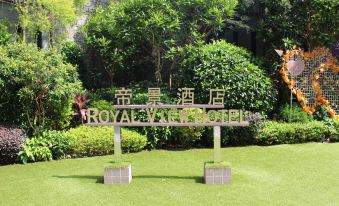 There is a sign surrounded by grass and flowers at the entrance to a different park at Royal View Hotel
