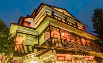 a large building with multiple floors and balconies , illuminated by colorful lights at night at Riverview Hotel