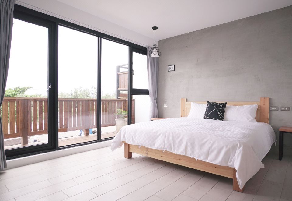 a spacious bedroom with a large bed and a sliding glass door leading to a balcony at Red House