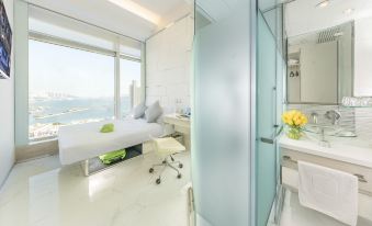 The room features a bed in the middle and a bathroom with large windows adjacent to it at iclub To Kwa Wan Hotel