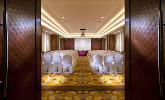 A spacious room at the hotel or conference venue is arranged with rows of chairs for an event at Wharney Hotel