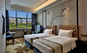 The bedroom features double beds and large windows that offer a beautiful view of the city at YiWu Zhonglian Kaixin Hotel