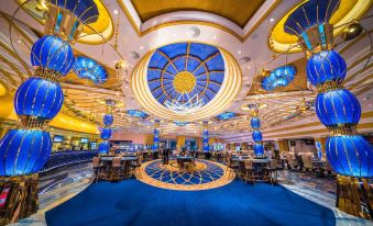 a large , luxurious hotel lobby with high ceilings , chandeliers , and blue carpeted floors , decorated with gold accents and a blue at Kings Casino & Hotel