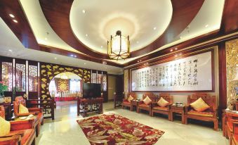 a luxurious lobby with a large chandelier , wooden furniture , and an oriental carpet on the floor at Silver Sea Hotel