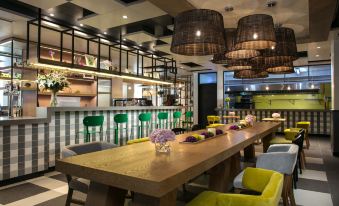 In the center of the restaurant, there are wooden tables and chairs, as well as an open concept kitchen at Campanile Hotel (Shanghai Jing'an)
