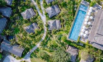 an aerial view of a resort with a pool surrounded by palm trees and buildings at Lahana Resort Phu Quoc & Spa