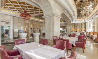 a large , elegant dining room with red chairs and tables set up for a formal event at Regency Hotel