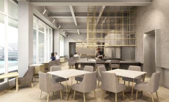 a modern dining area with multiple tables and chairs , as well as people sitting at the tables at Hotel Anteroom Naha