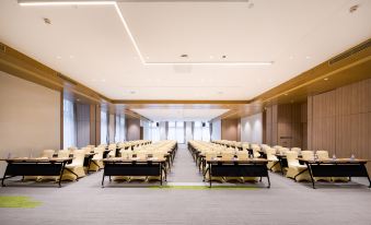 The conference room is spacious, featuring rows of long tables in the middle, and an empty area at Atour Hotel (Shenzhen Nanshan Vanke Yuncheng)