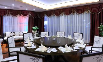 There is a spacious dining room with a long table and chairs arranged for ten people in the center at Hisoar Hotel