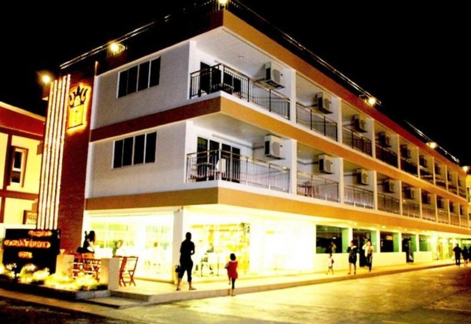a large hotel building with a yellow sign and people walking in front of it at That Phanom River View Hotel