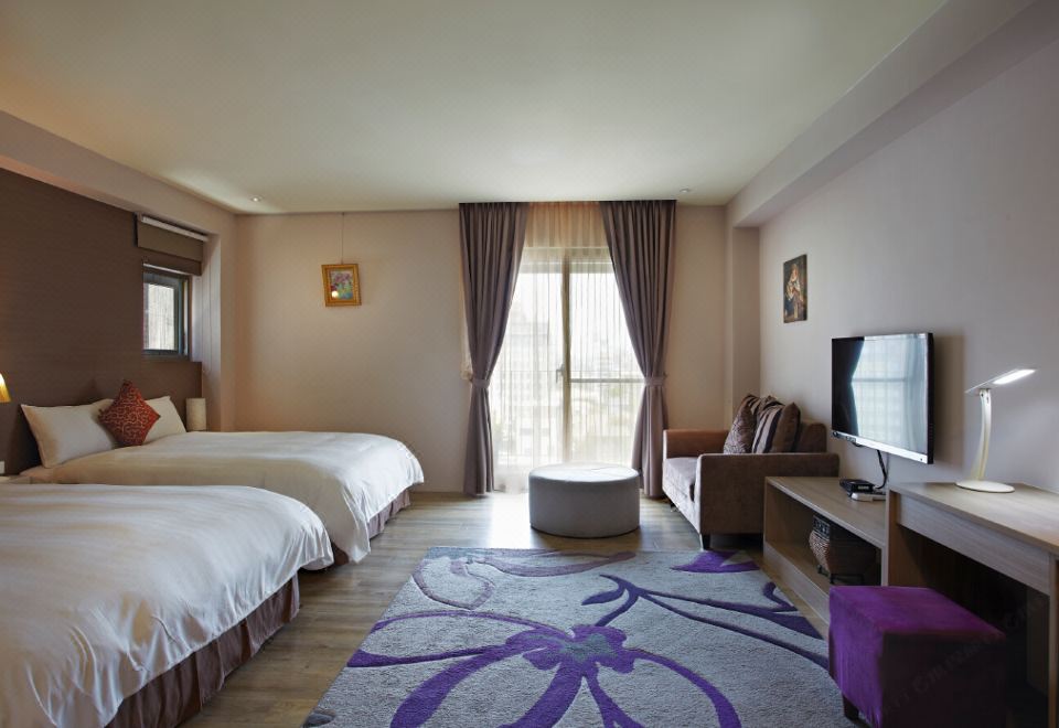 a modern bedroom with two beds , a tv , and a living area with a couch at Micasa Hotel