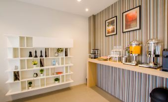 a white shelf with various items on it and a counter with various objects in the background at Fortune D Hotel Loei