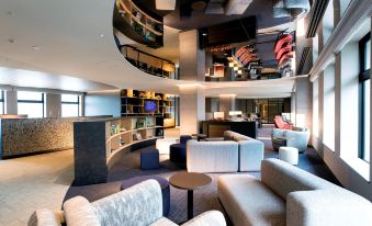 a modern living room with multiple couches , chairs , and tables arranged around the room , creating a comfortable space for socializing at Centrair Hotel