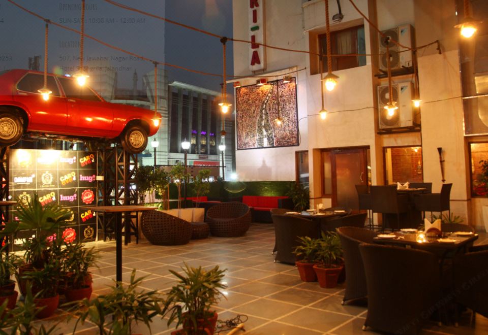 a dining area with tables and chairs , as well as a tv mounted on the wall at Hotel Shangri la