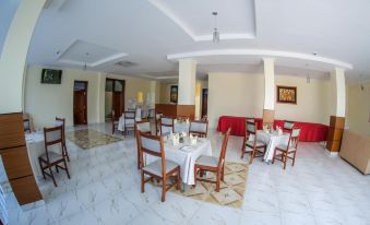 a large dining room with multiple tables and chairs arranged for a group of people to enjoy a meal together at Fatima Hotel