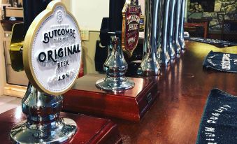 "a row of beer taps on a wooden bar , with one tap labeled "" sundowner original "" and another labeled "" strawberry ""." at King William Inn