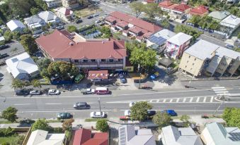 an aerial view of a street with buildings , cars , and people , possibly in a residential area at Brisbane Backpackers Resort