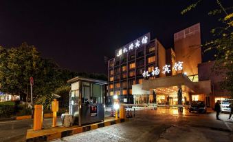 a nighttime scene of a hotel entrance , with the hotel 's name displayed on a building at Airport Hotel