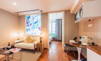 The suite features a spacious living room with large windows and an adjoining bedroom at Moka Apartment (Guangzhou CUHK Cancer Hospital Taojin Subway Station)
