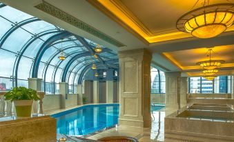 The interior of the hotel includes a spacious indoor pool and an arched ceiling adorned with reflective glass panels at Jinghu Hotel