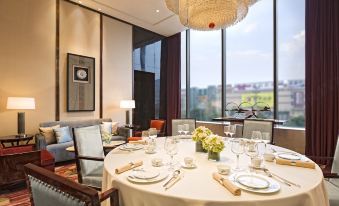 A dining room is arranged with large windows and a table for six in the center at Yiwu Marriott Hotel