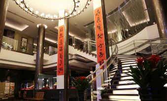 The large building has a lobby and entrance, with stairs leading up to additional rooms at Jinglun Hotel