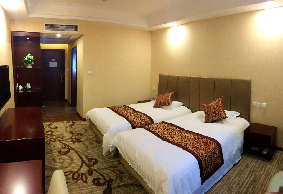 The bedroom is equipped with double beds and has an attached sitting area in the middle at Yuhang Hotel