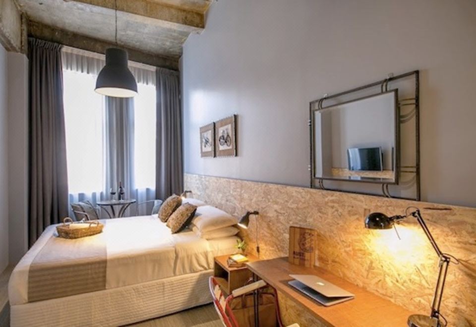 a modern bedroom with a large bed , wooden headboard , and a flat - screen tv on the wall at The Urban Newtown