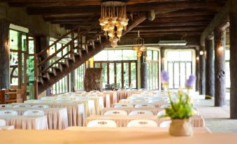 a large dining room with wooden floors and a staircase leading to the second floor at Blues River Resort