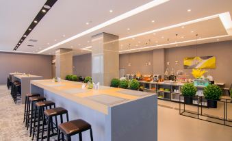 a restaurant with tables and chairs in the middle, next to an open kitchen that has a clear view for customers at Home Inn (Shanghai North Bund Dalian Road Subway Station)