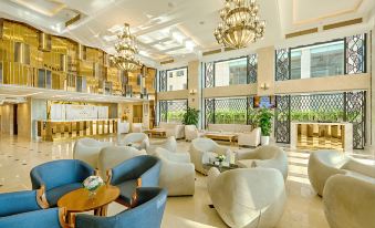 a luxurious hotel lobby with multiple seating areas , including couches , chairs , and a dining table at Paris Deli Danang Beach Hotel