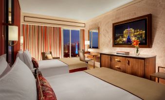 The bedroom features large windows, a king-sized bed, and a desk on the far side at The Parisian Macao