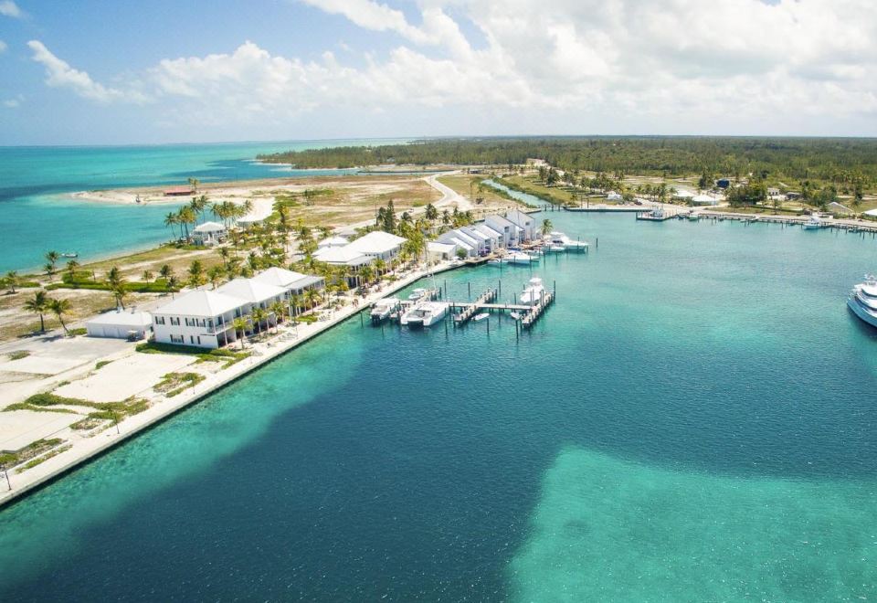 aerial view of a marina with multiple boats docked , surrounded by buildings and a body of water at Cape Eleuthera Resort & Marina