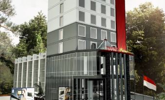 a tall building with a red flag on top , surrounded by trees and other buildings at Pakons Prime Hotel