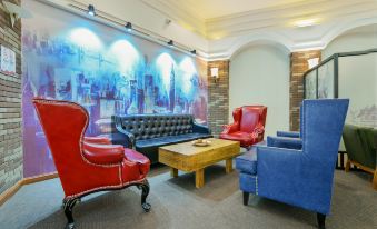 In front of the room, there are red chairs and tables, and along the wall, there is an artwork at Jingcheng Business Hotel (Beijing Shilihe Metro Station)