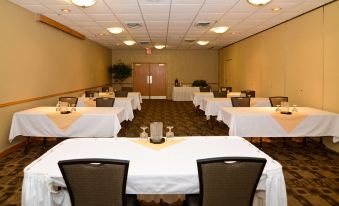 a conference room set up for a meeting , with tables and chairs arranged in rows at Best Western Tomah Hotel