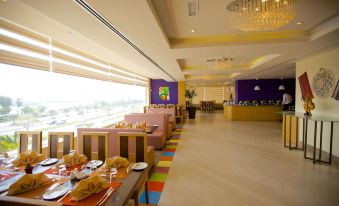 a restaurant with various seating options , including couches and chairs , as well as a dining area with tables and chairs at Mangrove Hotel