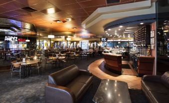 a large dining area with multiple tables and chairs , a bar , and a seating area at Nightcap at Matthew Flinders Hotel