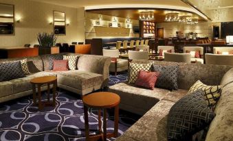 a luxurious hotel lobby with multiple couches , chairs , and tables arranged for guests to sit and relax at Sheraton Grande Tokyo Bay Hotel