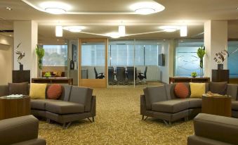 a spacious room with multiple couches and chairs arranged in various positions , creating a comfortable and inviting atmosphere at Pan Pacific Perth